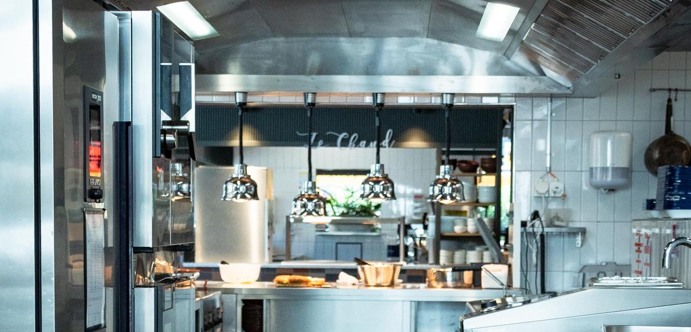 Cuisine de production en service : hotte, lampes chauffantes et passe